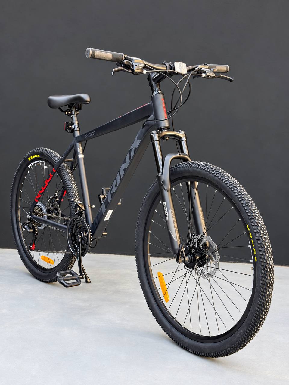 دراجة جبلية Trinx M007 مقاس 26 بوصة، إطار ألمنيوم، ناقل حركة Shimano بسرعة 21 سرعة، نظام تعليق أمامي قابل للقفل، فرامل قرص ميكانيكية 160 مم